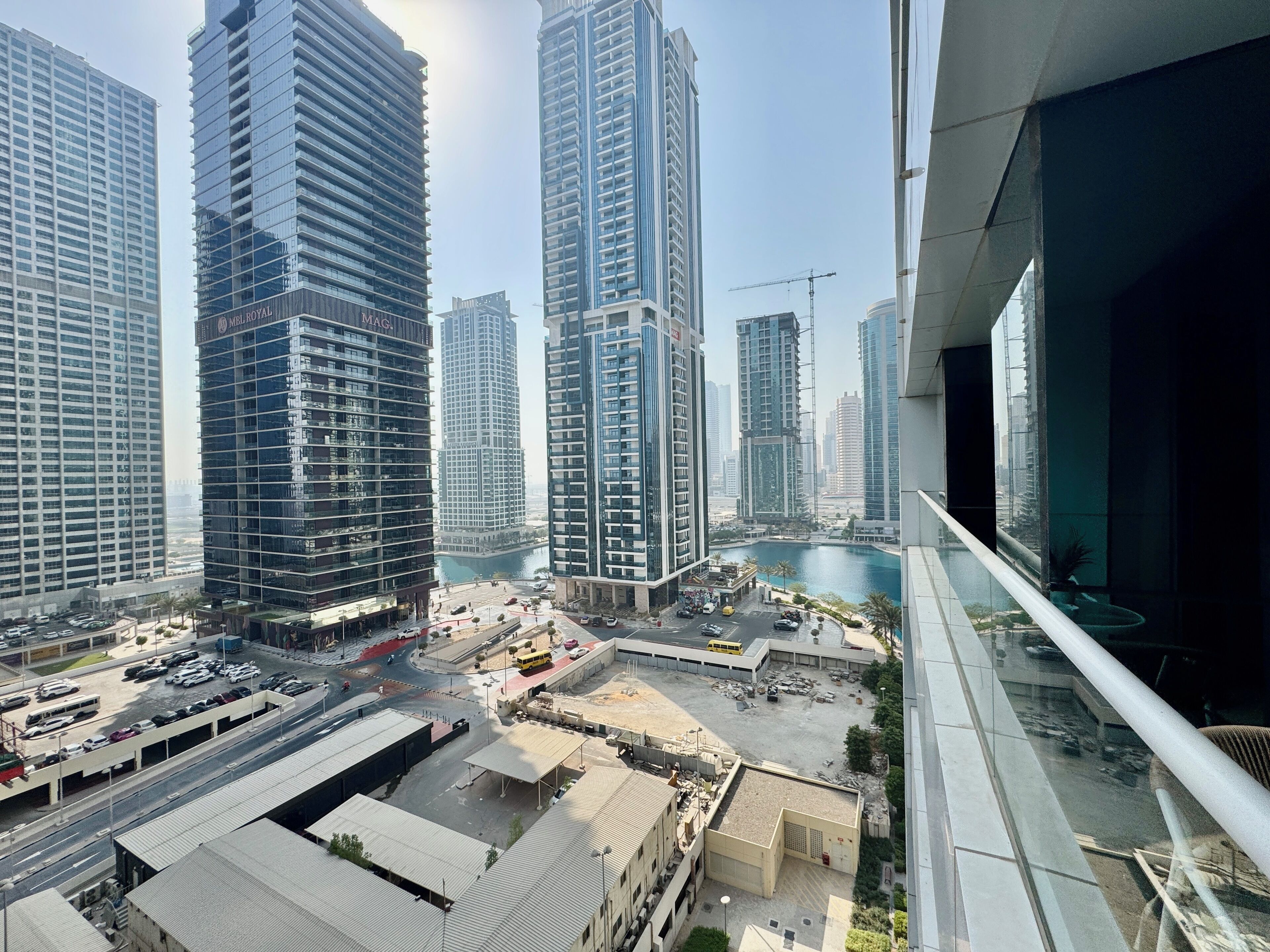 A high-rise urban area with modern buildings, a marina, and a construction site.