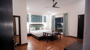 Una habitació d'hotel amb un llit, una taula de nit i una cadira.