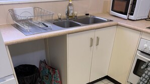 A kitchen with two sinks, a microwave, and an oven.