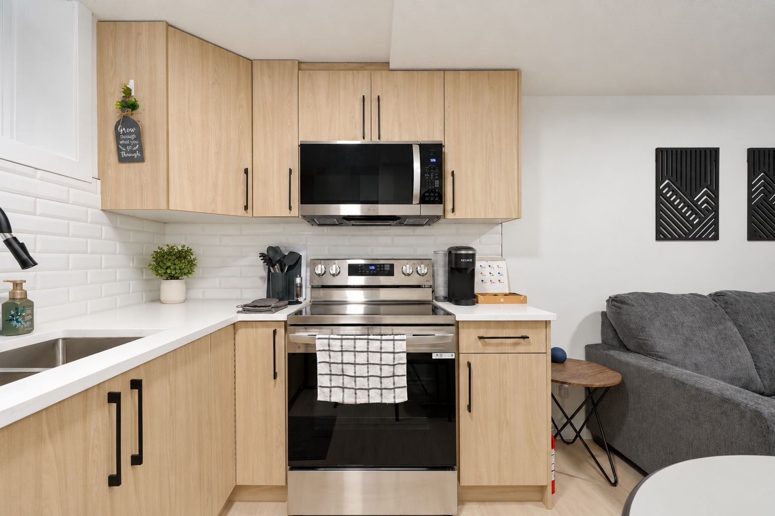 Una cucina moderna con mobili in legno, forno in acciaio inox, microonde e macchina da caffè.