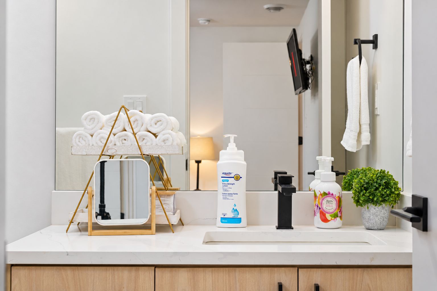 Bathroom vanity with soap and everyday essentials on a tidy counter
