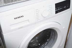 Una lavadora Siemens blanca con panel de control y pantalla digital.