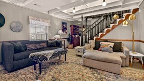 A spacious living room with a high ceiling, a staircase, and a large window. - Gorgeous mountain view cabin rental, hot tub, firepit, WiFi, pet-friendly (Ellijay)