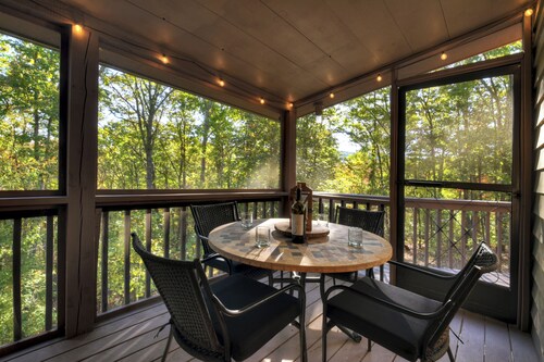 Big Bear Hideaway welcomes pets and boasting a majestic mountain vista, hot tub, firepit, WiFi, and a sprawling screened porch