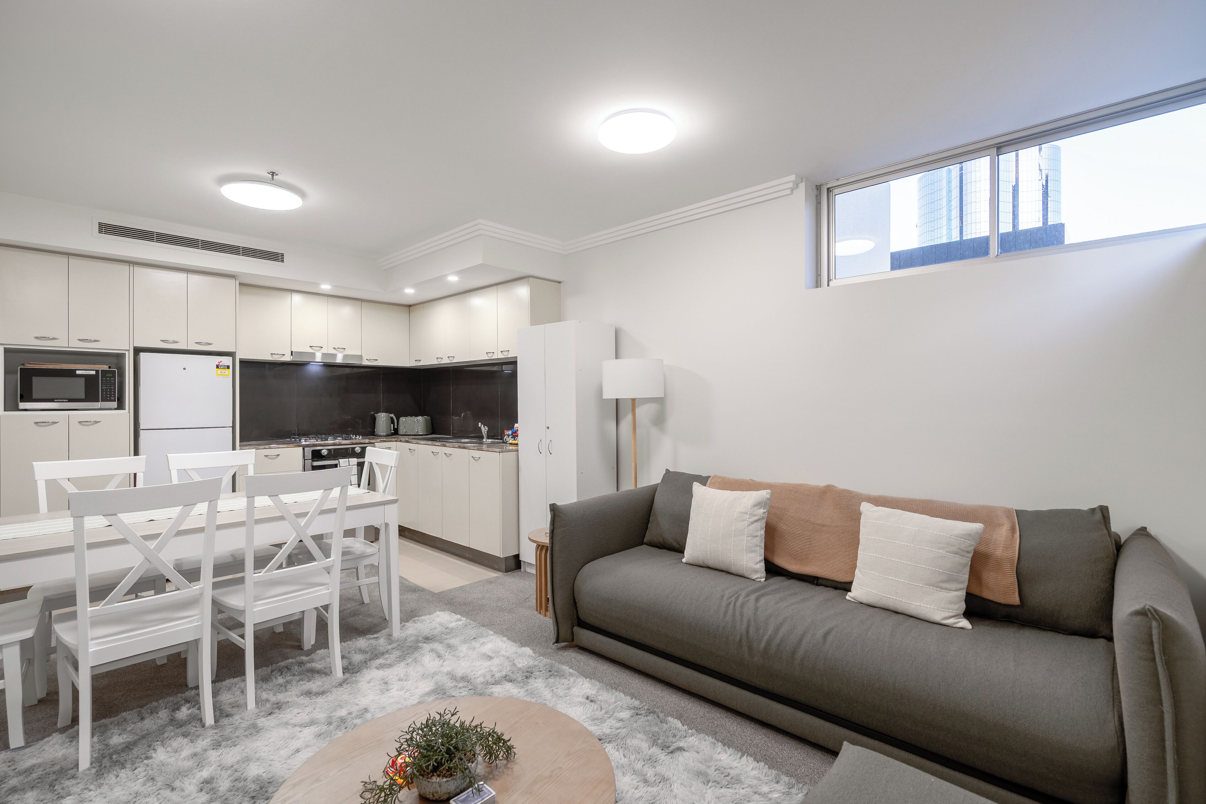 A modern apartment with a dining area, kitchen, and living room.