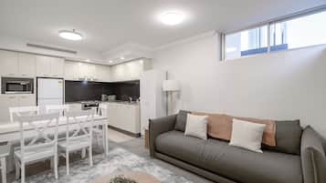A modern apartment with a dining area, kitchen, and living room.