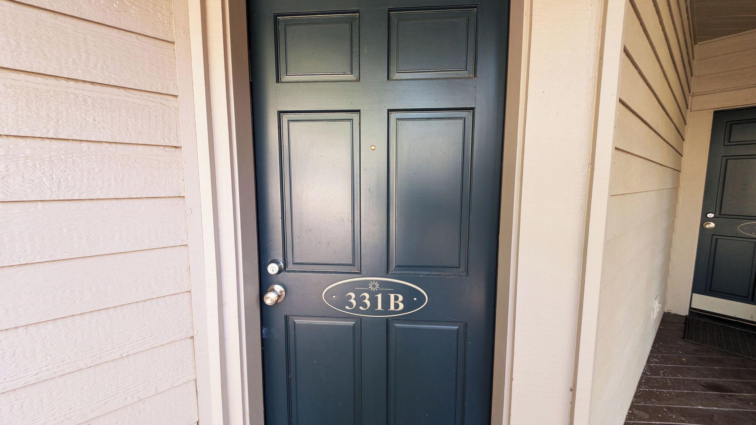 A dark-colored door with a white address plate reading "331B".