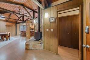 Un intérieur en bois avec une cheminée en pierre, un coin repas et une cuisine.