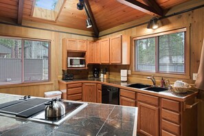 A modern kitchen with wooden cabinets, a microwave, a toaster, and a kettle. - 7 Bobcat - Hot Tub, SHARC, Close to Village, A/C (Sunriver)