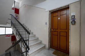 A staircase with a metal railing leading to a wooden door with a sign above it. - Sparano mood 170 - central cozy stay (Bari)