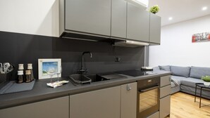 A modern kitchen with grey cabinetry, a built-in oven, and a stainless steel sink. - Sparano mood 170 - central cozy stay (Bari)