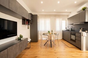 A modern kitchen with a dining area, built-in appliances, and a flat-screen TV. - Sparano mood 170 - central cozy stay (Bari)