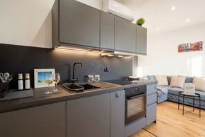A modern kitchen with grey cabinets, a built-in oven, and a sink. - Sparano Mood 170 - Central Location, Cozy Stay (Bari)