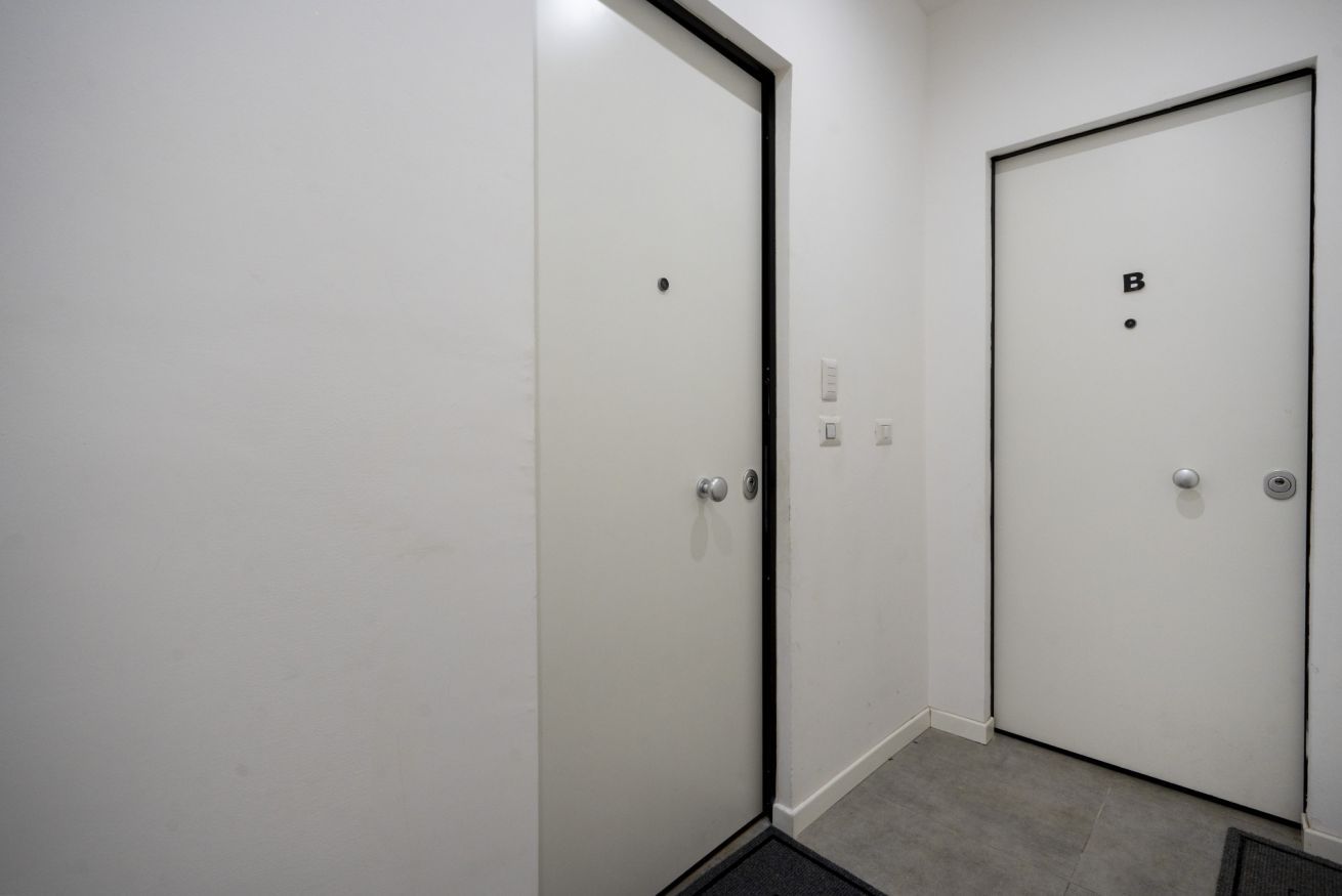 A hallway with two white doors, one marked with a 'B' and the other with a dot.