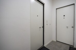 A hallway with two white doors, one marked with a 'B' and the other with a dot. - Sparano mood 170 - central cozy stay (Bari)