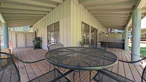 A covered patio with a round metal table and chairs, a grill, and a hot tub. - Circle Four Condo 14 - Hot Tub, SHARC Passes, Community Pool (Sunriver)