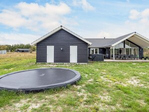 A house with a large patio area, a trampoline, and a hot tub. - 5 Star Holiday Home in Jerup (Jerup)
