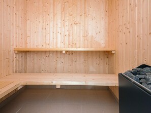 A sauna room with wooden walls and benches. - 5 Star Holiday Home in Jerup (Jerup)
