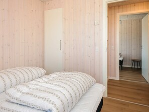 A bedroom with a bed, a wardrobe, and a door leading to a bathroom. - 5 Star Holiday Home in Jerup (Jerup)