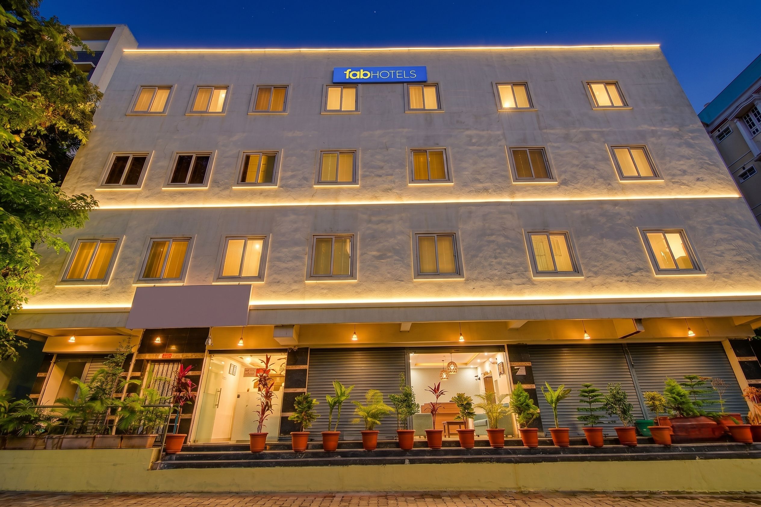 Ein mehrstöckiges Hotelgebäude mit einer Beschriftung 'fabHOTELS' auf dem Dach.
