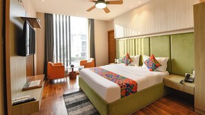 A hotel room with a large bed, a television, a desk, and a chair. - Fabhotel Elbeso (Dera Bassi)