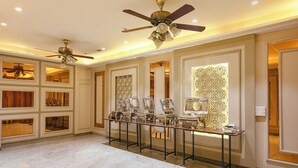 A spacious room with marble flooring, a central table displaying various items, and two ceiling fans. - Fabhotel Elbeso (Dera Bassi)