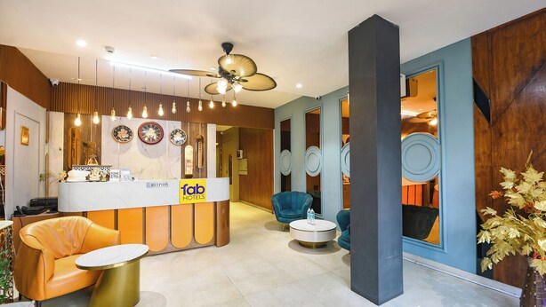 A hotel reception area with a reception desk, a ceiling fan, and seating arrangements. - Fabhotel Elbeso (Dera Bassi)