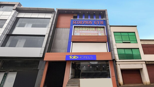 Un bâtiment sur lequel on peut voir une enseigne indiquant « Scorpion Gym » et une autre indiquant « Fab Hotels ».