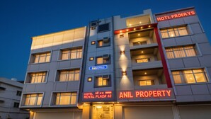 Ein mehrstöckiges Hotel mit Balkonen, einem Schild mit der Aufschrift 'HOTEL ROYAL PLAZA 62' und Branding von 'ANIL PROPERTY'.