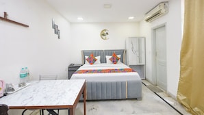 A bedroom with a bed, bedside table, and a wardrobe. - Fabhotel The New Moon (New Delhi)