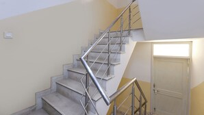 A staircase with metal railings and a door at the bottom. - Fabhotel The New Moon (New Delhi)