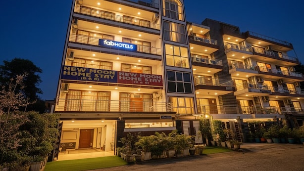 A multi-story hotel with balconies, a sign for 'FabHotels', and a 'New Moon Home Stay' sign. - Fabhotel The New Moon (New Delhi)