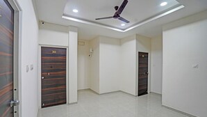 A hotel corridor with a ceiling fan, recessed lighting, and two doors with number plaques.