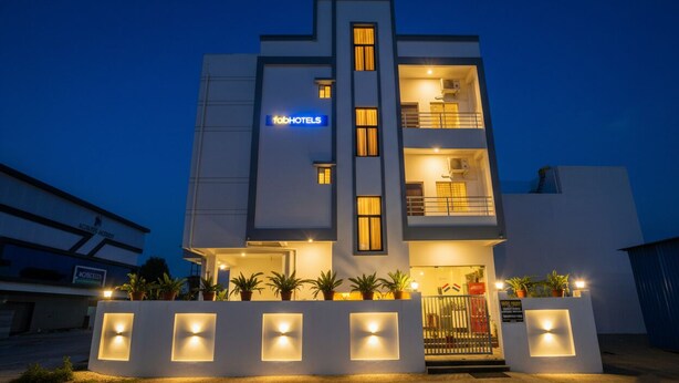 A modern hotel with a flat roof, multiple floors, and a prominent 'Tab Hotels' sign.