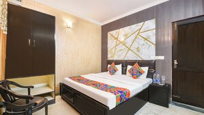Une chambre d’hôtel avec un grand lit, un bureau et une armoire.