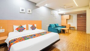 Una habitación de hotel con cama, sofá, escritorio y armario.