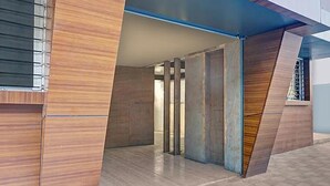 A modern building with a sloped roof and a mix of wooden and concrete materials. - Fabhotel Stay One (Mawal)