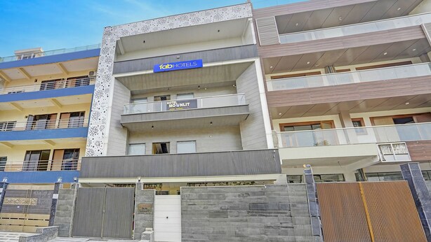 A multi-story hotel with a modern facade, balconies, and a gated entrance. - Fabhotel Moonlit (Noida)