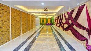 A hallway with a marble floor, a ceiling fan, and draped curtains. - Fabhotel Moonlit (Noida)