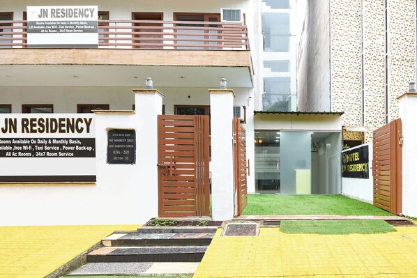 L’entrée d’un hôtel, avec un panneau indiquant les chambres disponibles, les services proposés et les coordonnées.