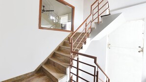 Una escalera con barandilla de madera y un espejo en la pared.