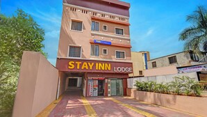A multi-story building with a sign reading "STAY INN LODGE". - Fabhotel Stay Inn Lodge (Pune)