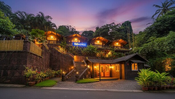 Un hotel dallo stile di bungalow con facciata in pietra, una scala centrale e un cartello con la scritta "fabHOTELS".
