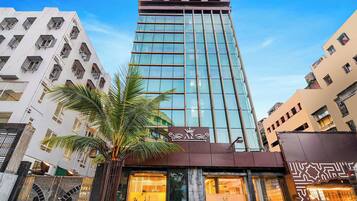 A tall hotel building with a modern glass facade and a sign reading "fabHOTELS".