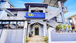 A modern hotel with a prominent 'fabHOTELS' sign, a covered entrance, and a staircase leading to the upper floors. - Fabexpress Elvin Balaji Beach Palace (Calangute)