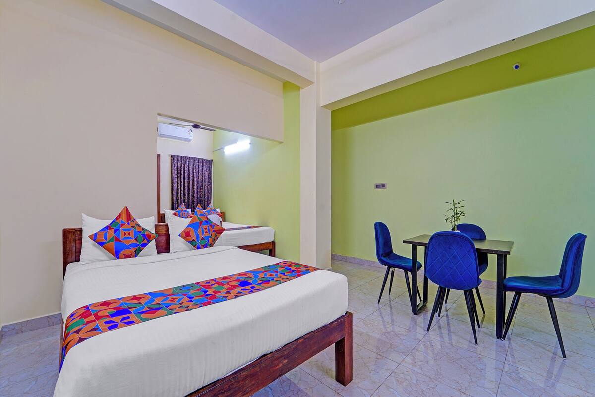 Habitación de hotel con una cama, un escritorio y dos sillas.