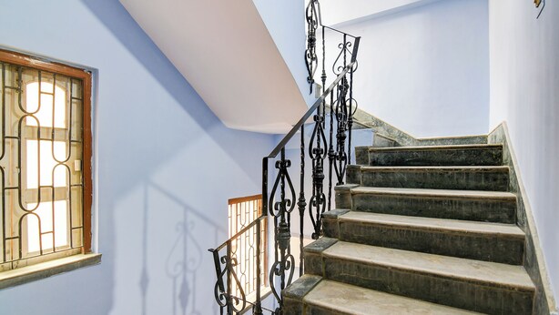 A staircase with ornate black metal railings and stone steps. - Fabhotel Vedsri (Kolkata)