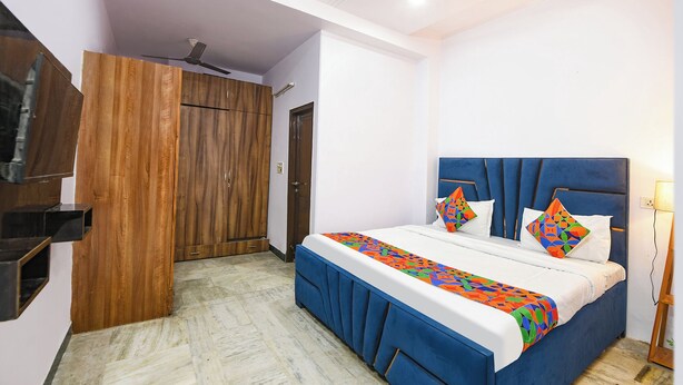 Une chambre à coucher avec un lit, une armoire et un ventilateur de plafond.