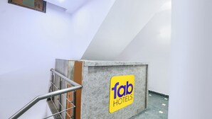 Un escalier avec une rampe métallique et une enseigne « Tab Hotels » sur un mur.
