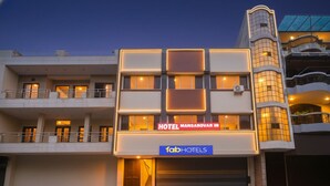 Un hôtel moderne, reconnaissable à son enseigne où l’on peut lire « HOTEL MANSAROVAR IN » et « fabHOTELS ».